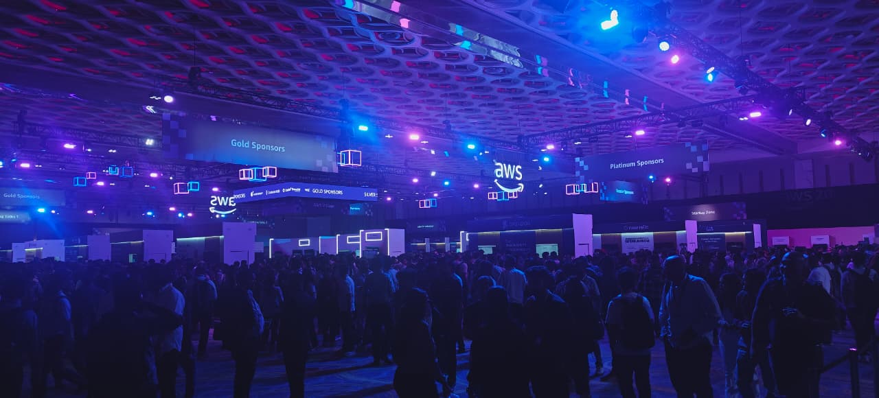 AWS Summit Mumbai 2026 expo hall — gold and platinum sponsor booths, AWS signage, packed crowd